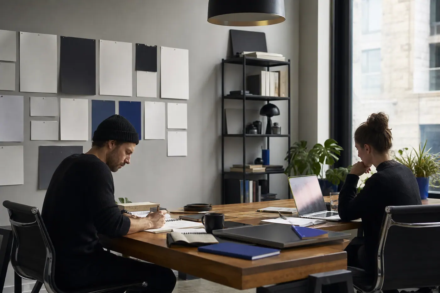 Scène conceptuelle de personnes qui examinent un travail numérique dans un environnement calme et partagé.